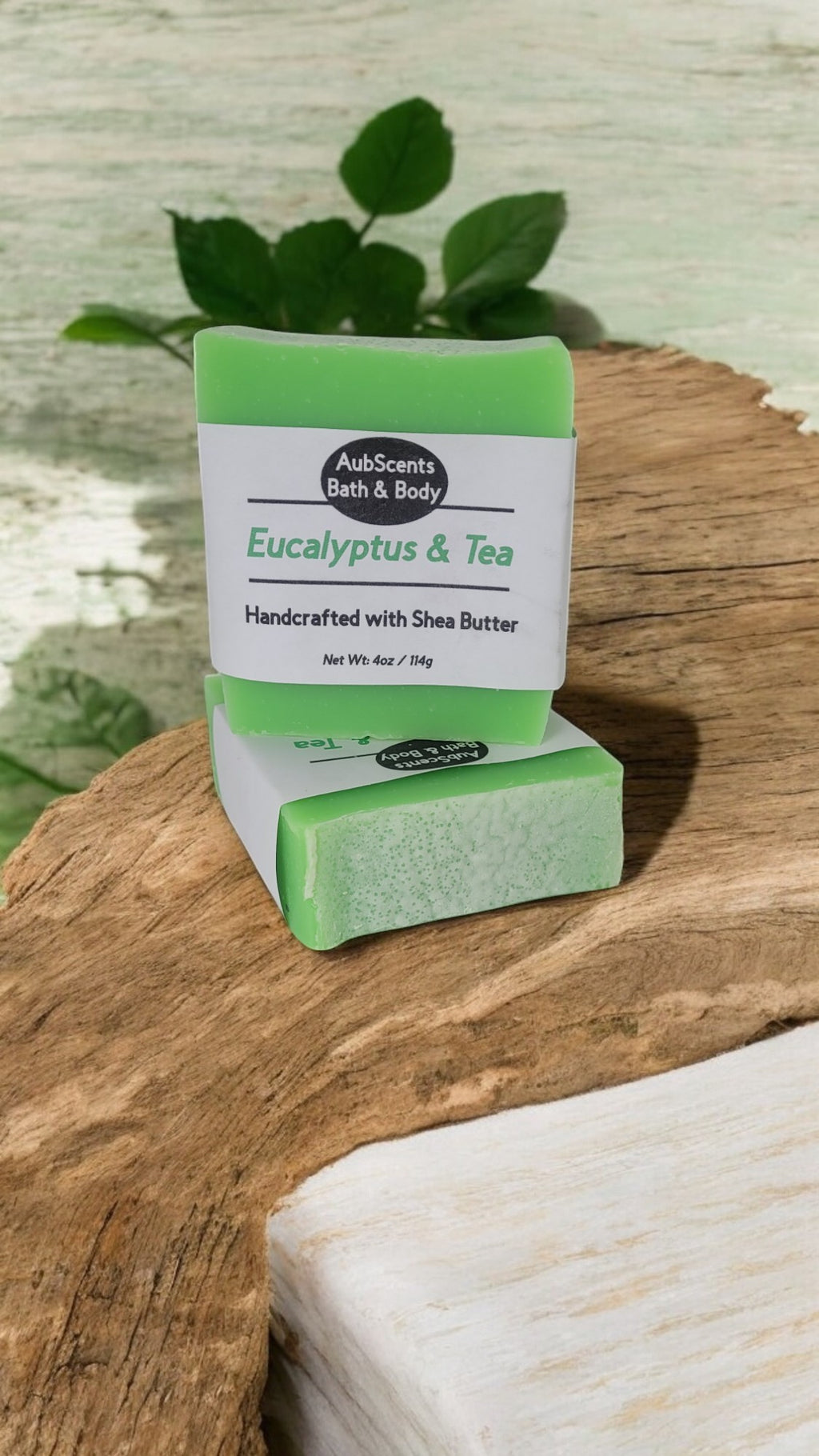 Handmade Eucalyptus & Tea Soap with shea butter and rice bran oil on a wooden surface with eucalyptus leaves.